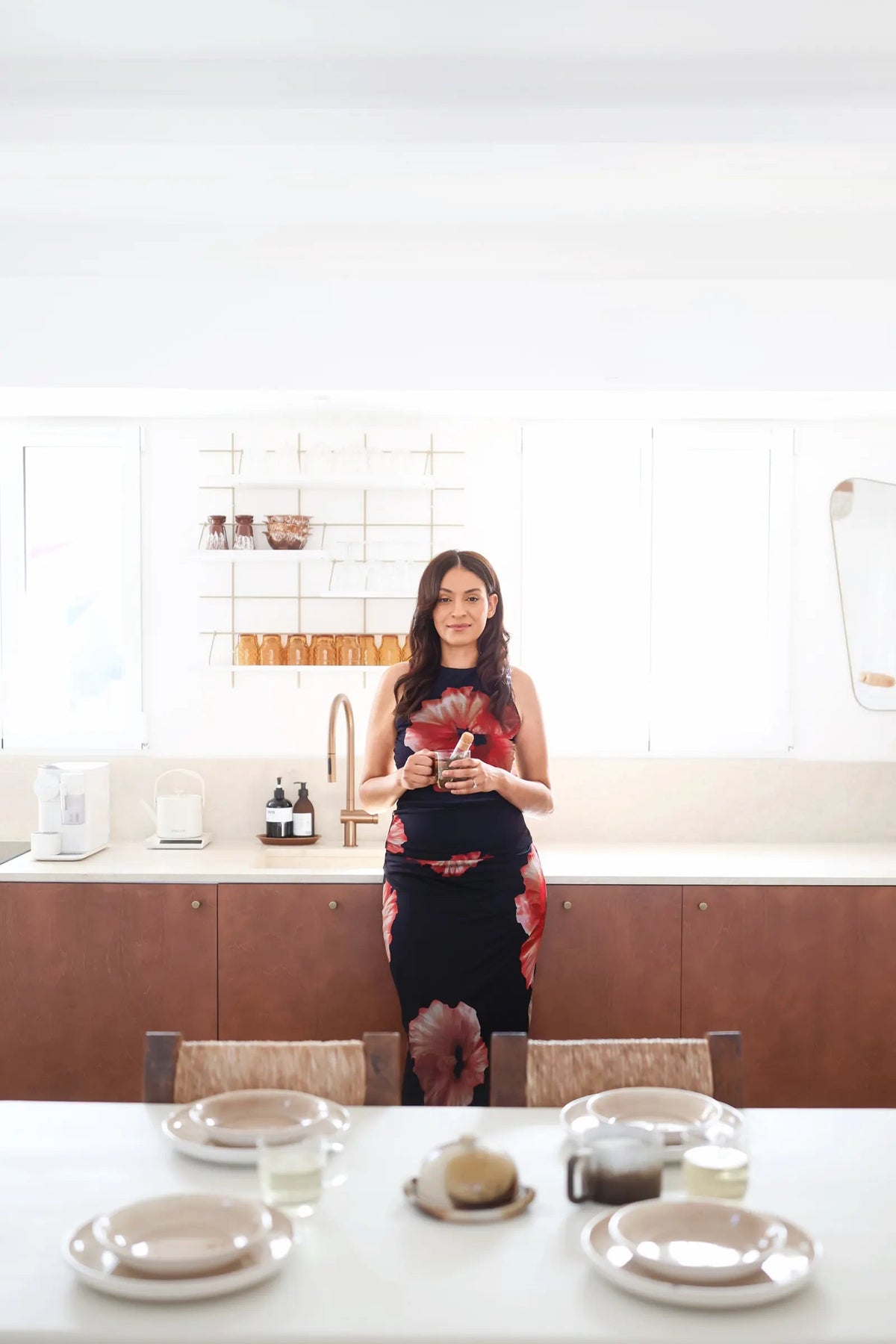 Sarah dans sa cuisine, une tasse d'infusion à la main